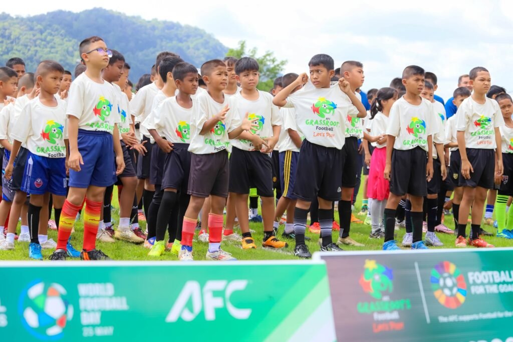 เยาวชนและผู้บริหารร่วมถ่ายภาพในกิจกรรม AFC Grassroots Football Day 2026 ที่สนามกีฬาฟุตบอล รัชกิจประการ จังหวัดสตูล